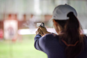 gun holding in hand of woman in practice shooting in martial arts for self defense in an emergency case