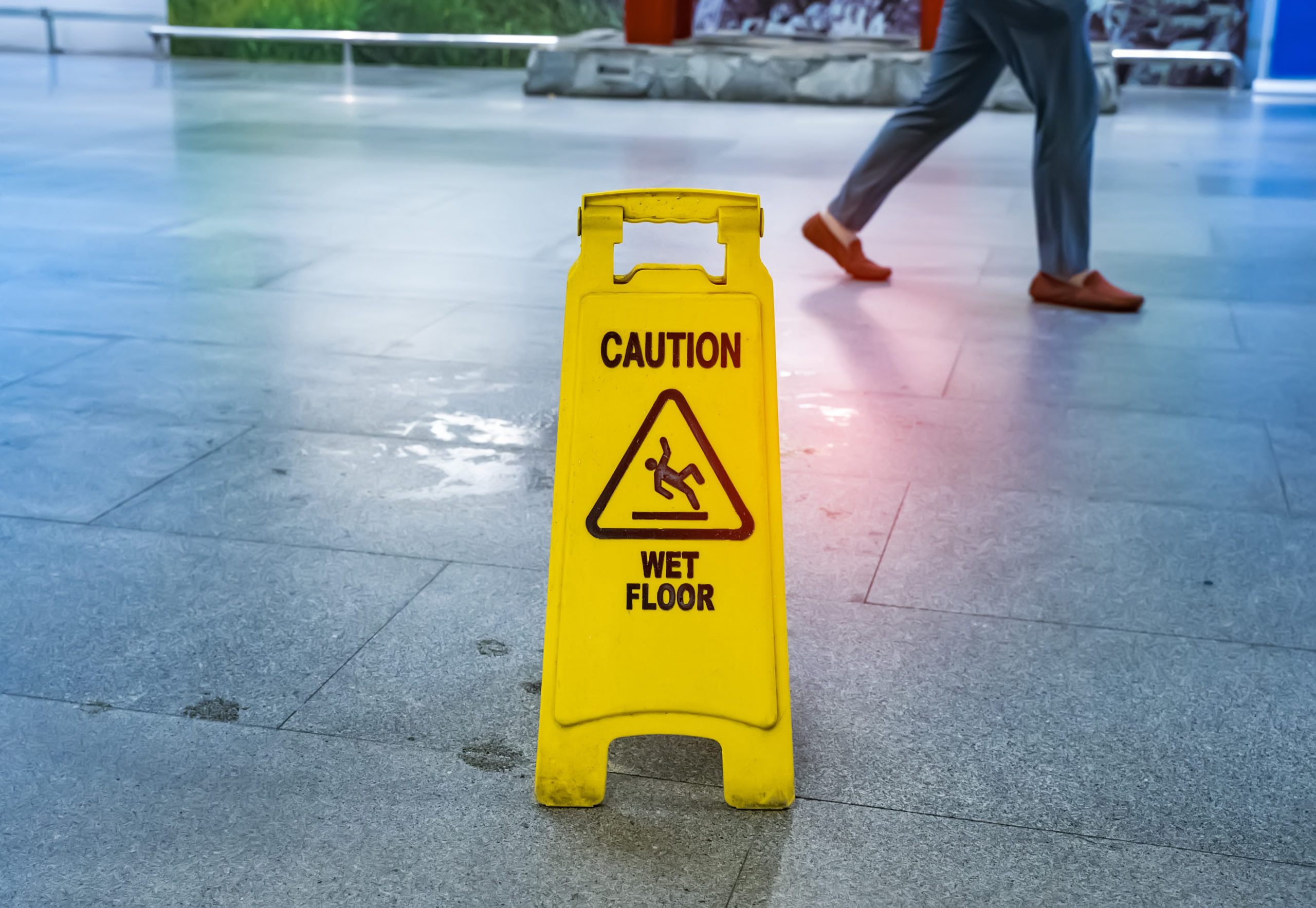 caution wet floor sign man walking nearby