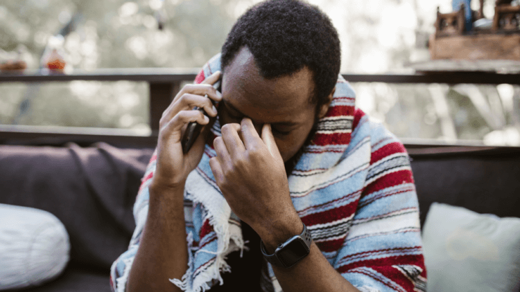 A man crying while speaking on the phone