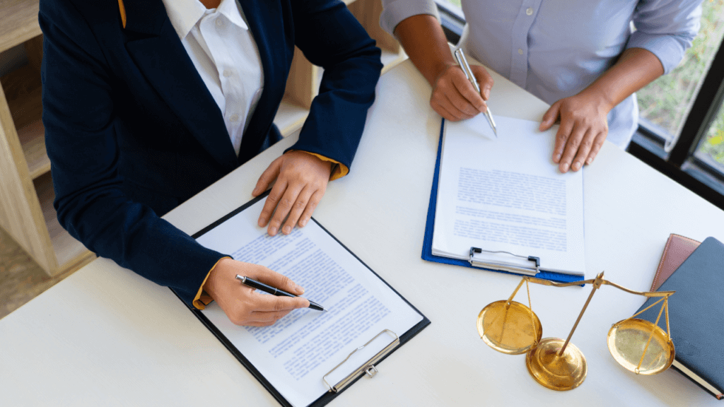 A lawyer and his client signing papers.