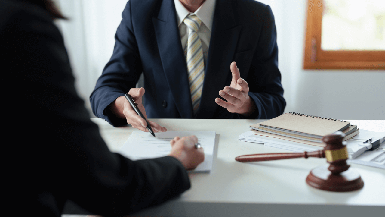 A lawyer and a client signing documents.