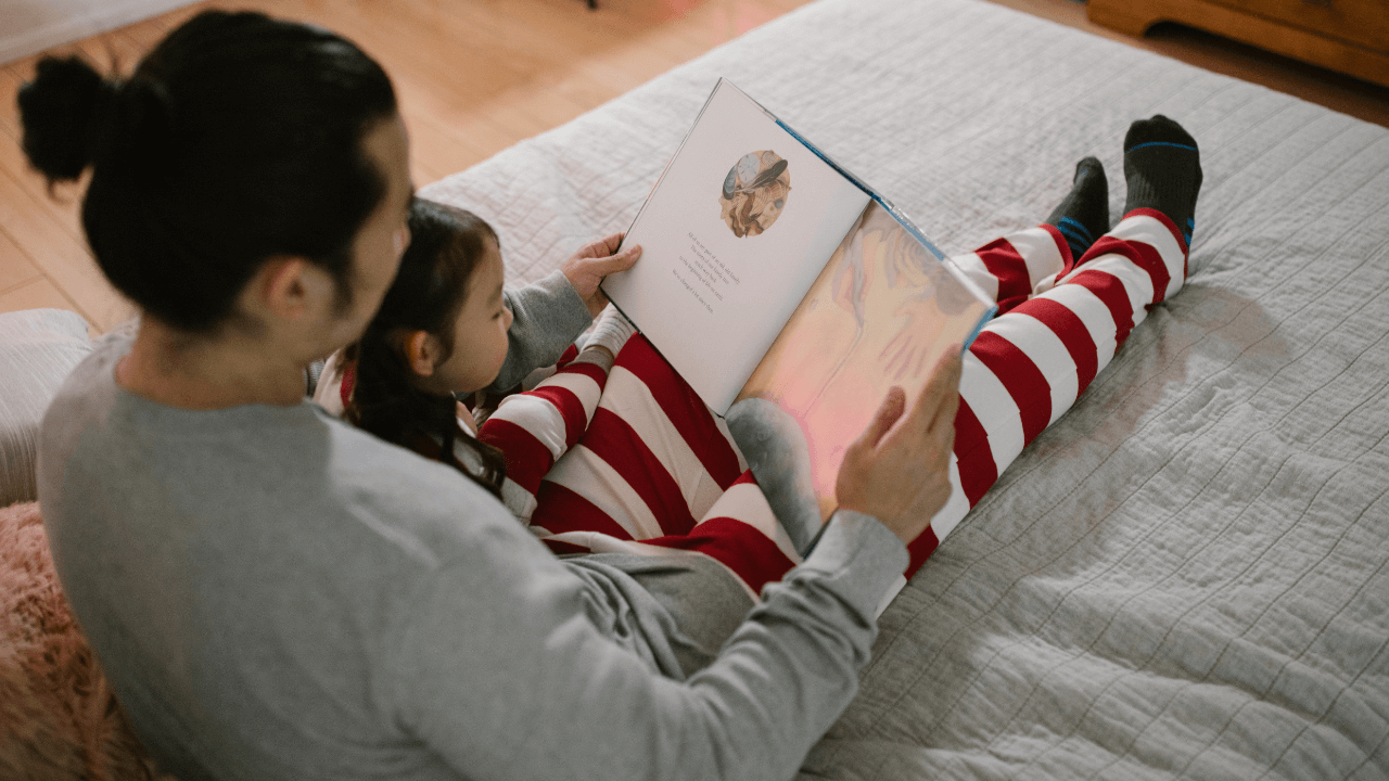 A child and a parent reading a book together.