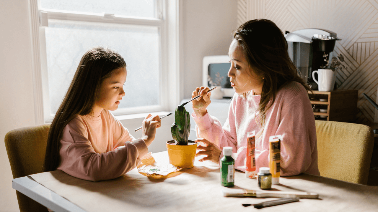 A mother and her child painting together.