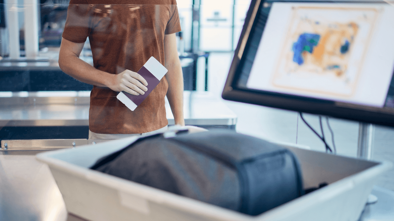 A man with his baggage going through airport security.