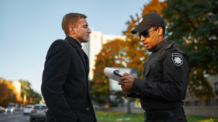 A police talks to a man outside.