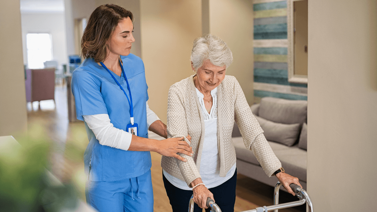 An elderly woman getting escorted by a nursing home staff.