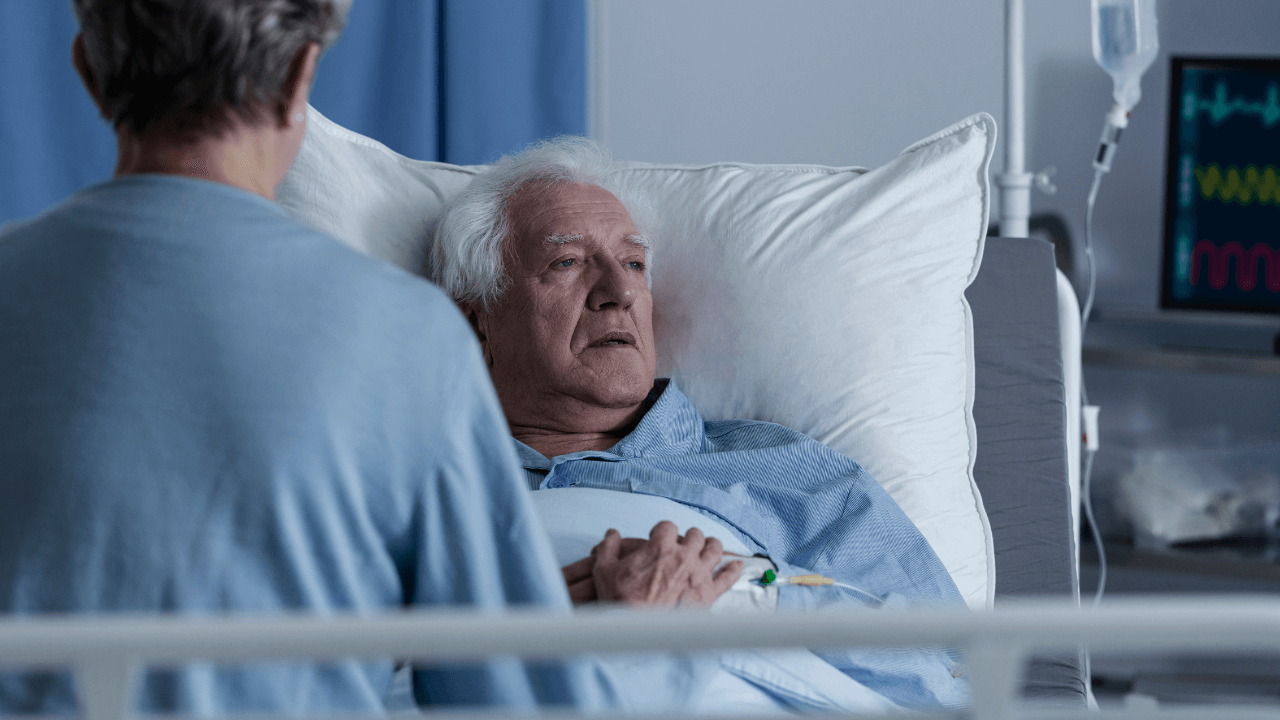 An old person lying on a hospital bed.